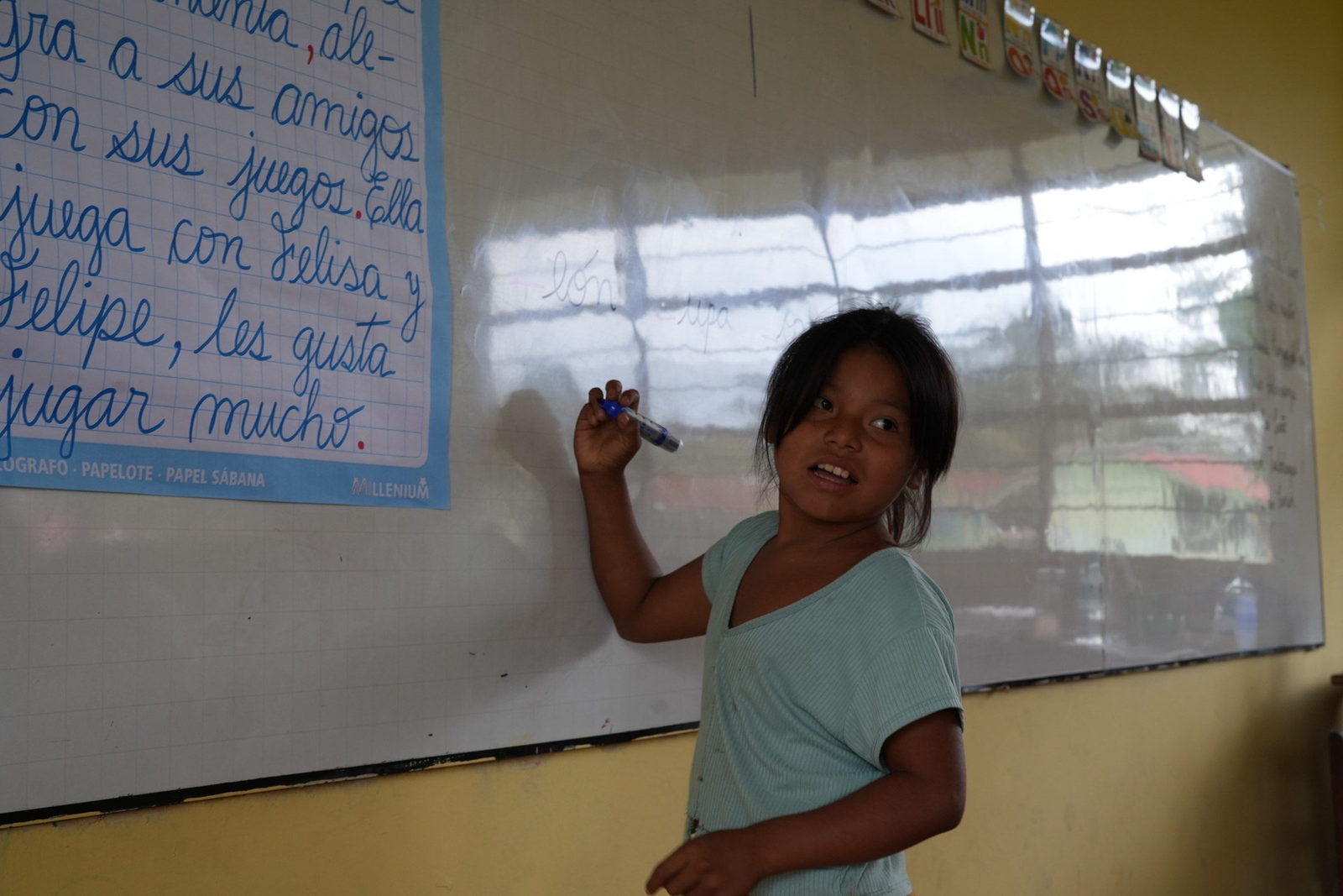 Una estudiante escribe en la pizarra durante una sesión del programa, en la institución educativa de Ticumpinía.